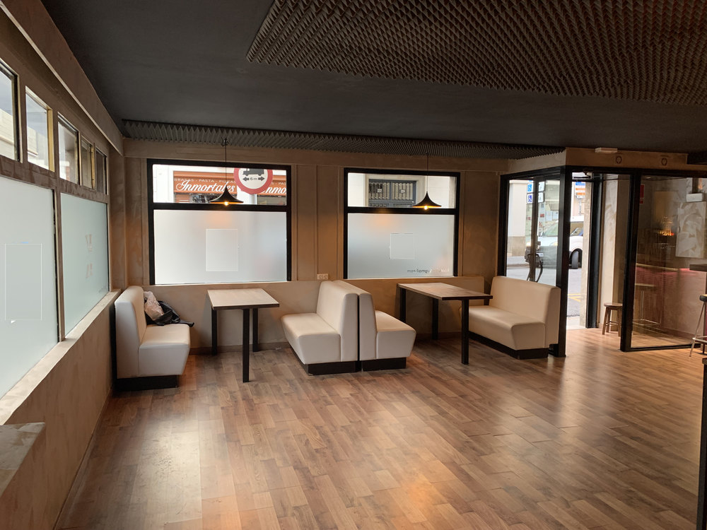 Sala Yellow en Barcelona, local diáfano a pie de calle con bancos tapizados, mesas bajas y ventanales a la calle